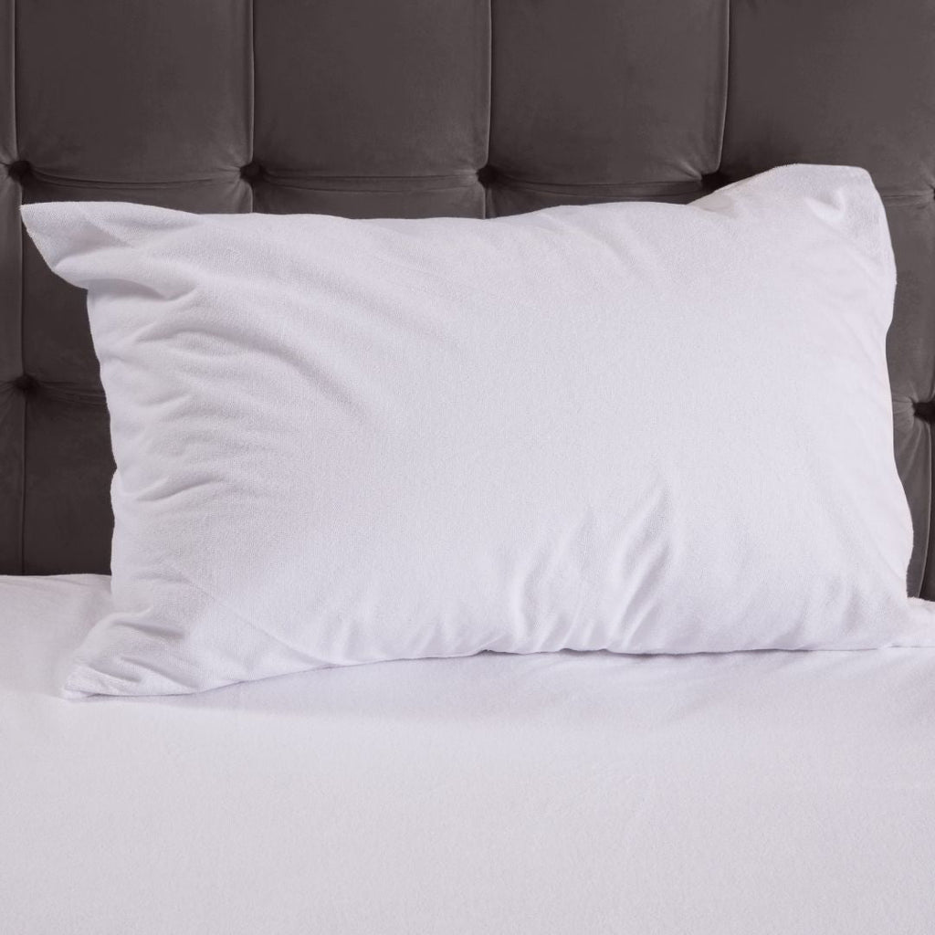 White pillow on a bed with a gray headboard