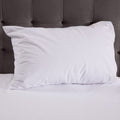 White pillow on a bed with a gray headboard