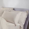 Beige pillowcases on a bed with a neutral background